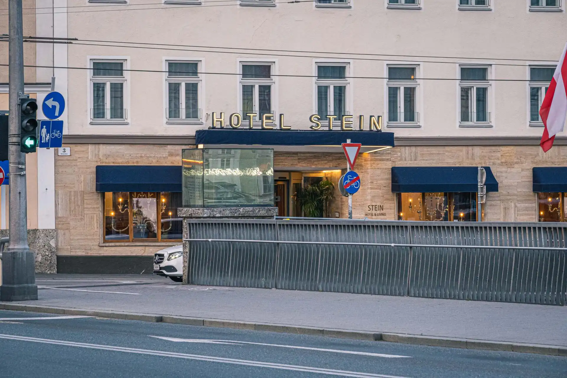 hotel stein entrance with golden signage on the salzach riverfront in salzburg